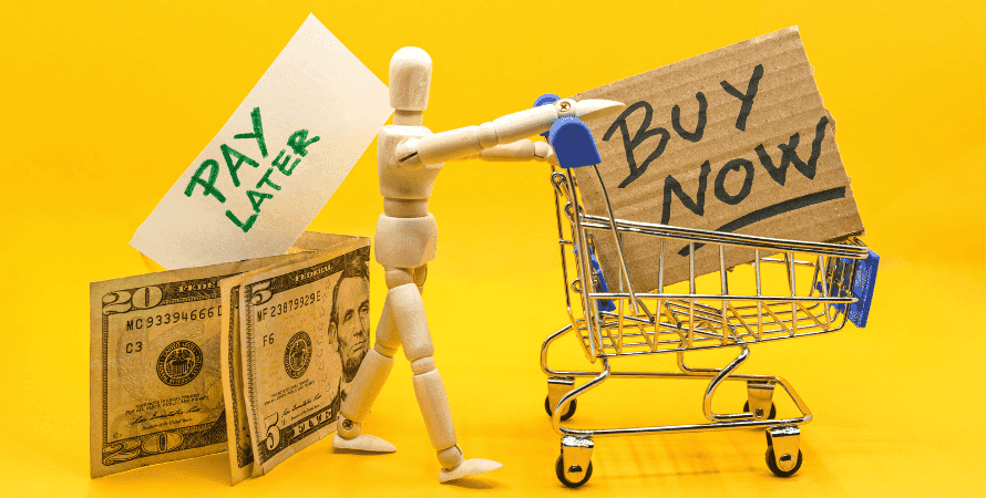 Foto de montagem de boneco segurando carrinho com escrita "buy now" de um lado e uma nota de dinheiro do outro com escrita "pay later"